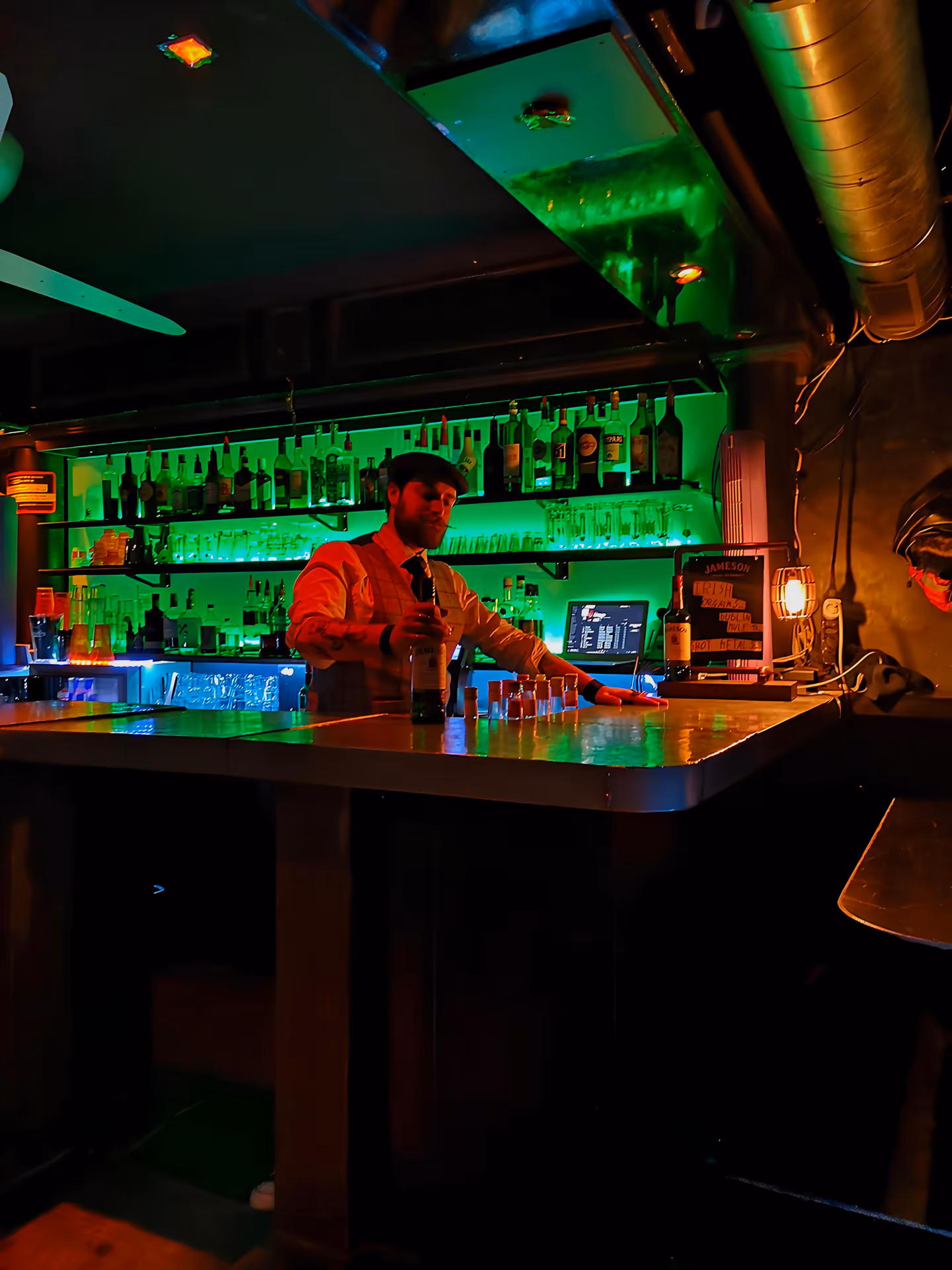 Le bar du Lapin Vert, l'étagère de bouteilles rétro-éclairée en vert, un soir de rock