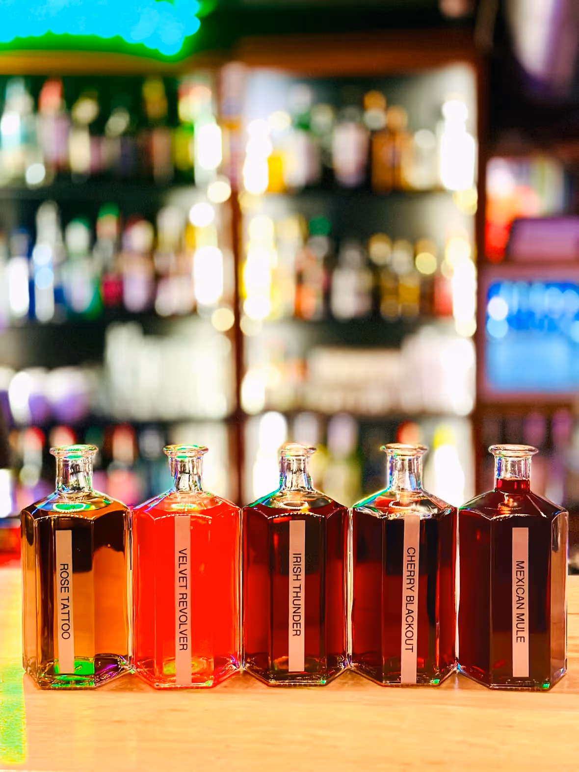 Les cinq infusions maison du Lapin Vert, alignées au comptoir devant les bouteilles du bar