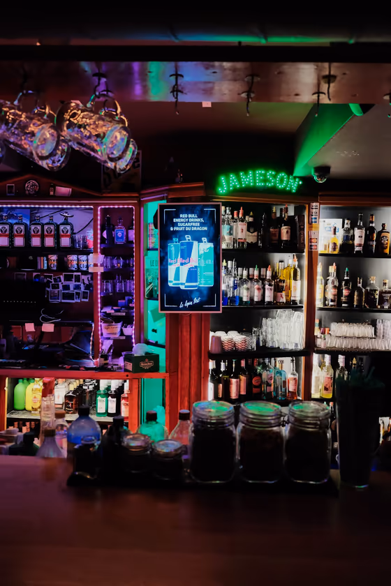 Le comptoir du bar et son néon Jameson vert